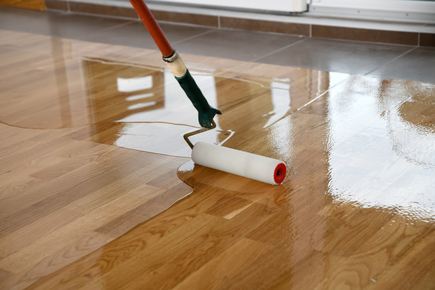 Lacquering,Wood,Floors.,Worker,Uses,A,Roller,To,Coating,Floors.
